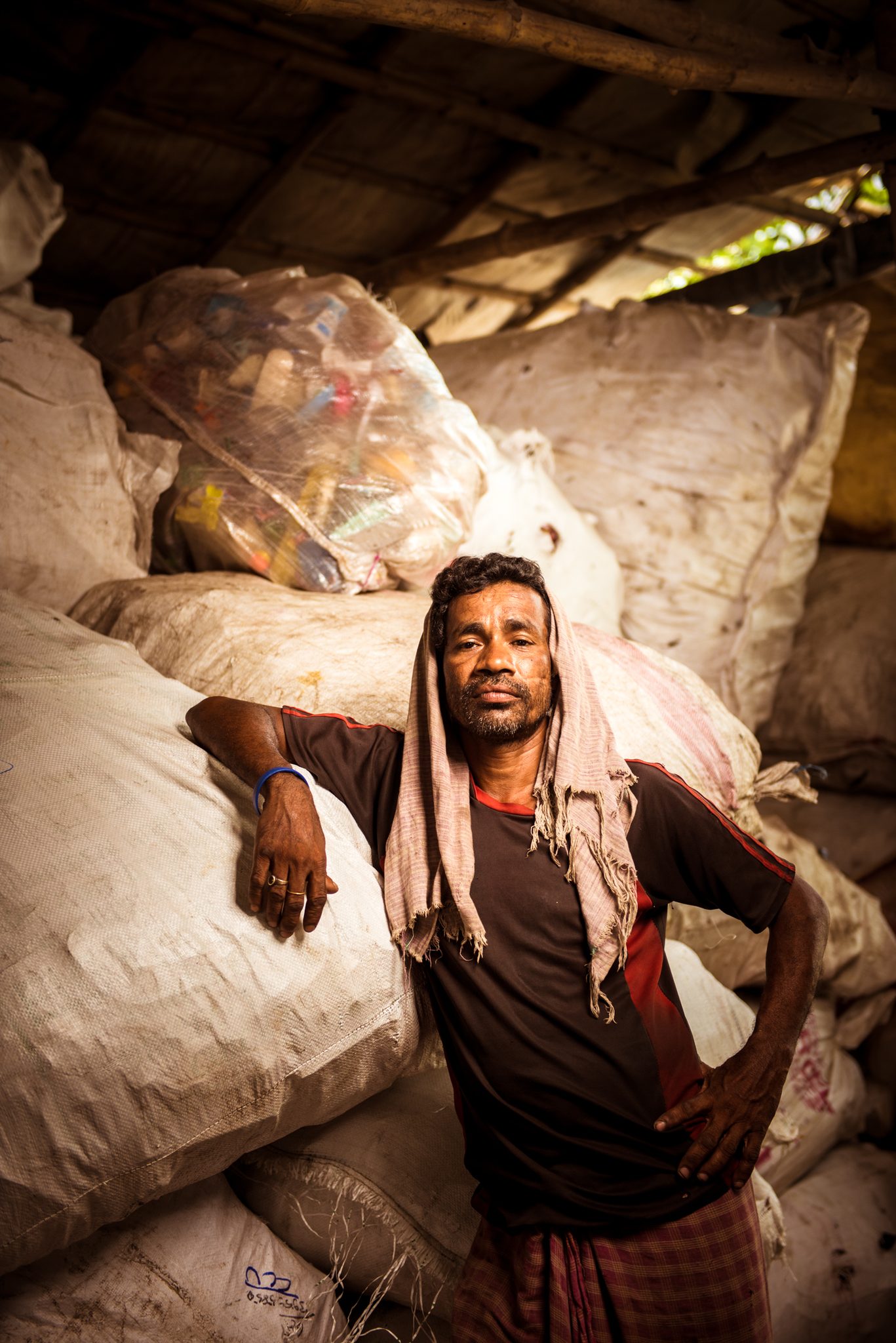 Man with bales of recycled plastic waset, kolkata. Portrait photograph by Slater King, finalist in the Shoot The Frame Portrait photography award, January 2021
